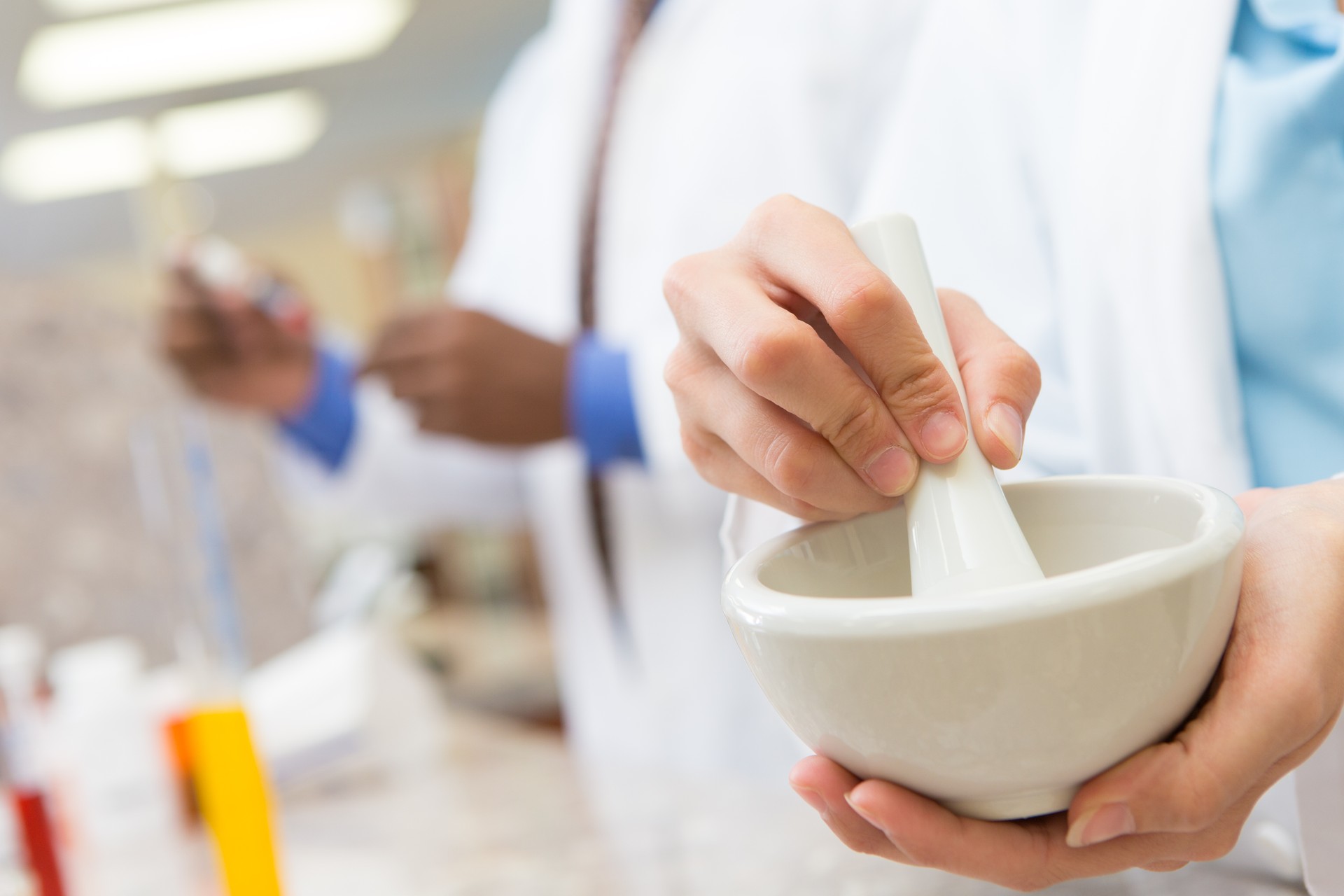 Pharmacist crushing pills to compound prescription medication